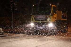 Fahrzeug des Winterdienst streut die Straße