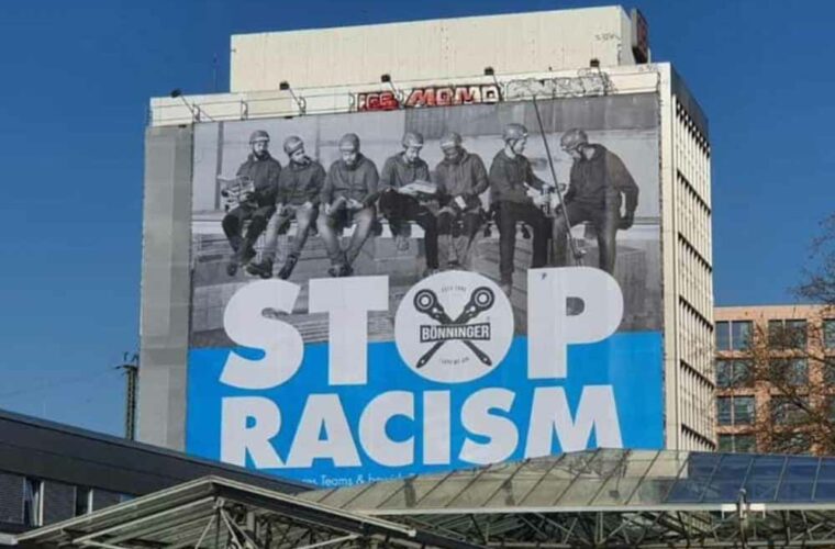 STOP RACISM! Es kann gar nicht groß genug geschrieben werden. 500 m2 sind jedoch ein kleiner Schritt in die richtige Richtung. Erneut setzt die Firma Bönninger Gerüstbau Dortmund am Hauptbahnhof mit Ihrem Plakat ein wichtiges Statement: STOP RACISM. Für diese Botschaft gab es viele positive Rückmeldungen, aber leider auch die ein oder andere negative Äußerung. Doch diese bestärkten das Team Bönninger nur noch mehr, dieses Werbeplakat erneut aufzuhängen. Für den Familienbetrieb gab es noch nie einen Grund, auf Herkunft, Geschlecht, Aussehen oder Orientierungen zu achten. Wer anpacken kann ist herzlich willkommen! Leider ist dies jedoch noch nicht der Regelfall. Auch in der heutigen Zeit ist die Gesellschaft geprägt von Rassismus und Diskriminierung. Viel zu oft werden die Augen verschlossen und es wird weggesehen, statt eingegriffen. Das Riesenplakat, direkt am Dortmunder Hauptbahnhof soll Augen öffnen. Aufmerksamkeit auf ein so unglaublich wichtiges Thema lenken: Gleichberechtigung. Deshalb ist unser Team, wie auf dem Bild erkennbar, schon immer multikulturell!